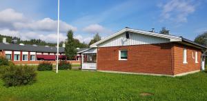 a large brick building with a grass field in front of it at Hus Klarälven in Stöllet +51 photos