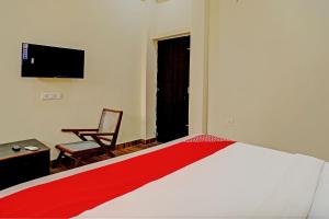 a bedroom with a bed and a chair and a television at Super OYO Flagship Sunrise Inn in Lucknow