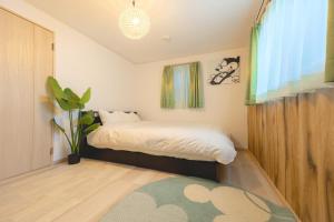 a small bedroom with a bed and a potted plant at CuteFamilyHouse! 8min Shinjuku 5minJR 3minSubway Cozy,Quiet KidsFree Under6yrs in Tokyo