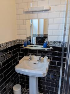 a bathroom with a sink and a mirror at Dolce Central Lord St. Flat 2 in Southport