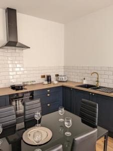 a kitchen with a table with wine glasses on it at Dolce Central Lord St. Flat 2 in Southport