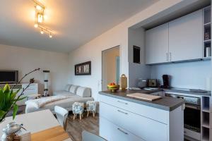 a kitchen and living room with white cabinets and a table at Ferienwohnung Aartalblick Willingen in Willingen