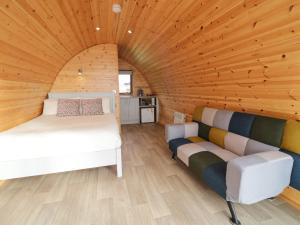 Cette chambre comprend deux lits et un canapé. dans l'établissement The Wheelhouse Pod No 3, à Letterkenny