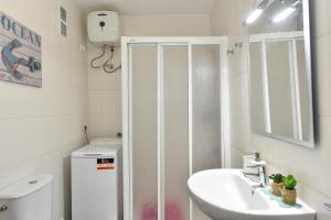 a white bathroom with a sink and a shower at Beach Apartment in Playa del Cura 323 in Mogán