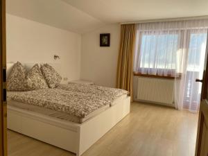 1 dormitorio con cama y ventana grande en Haus Reichlas en Längenfeld