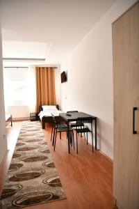 Apartmani swiss Gold في Priboj: غرفة معيشة مع طاولة وكراسي وأريكة