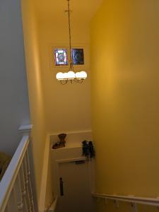 a stairway with a yellow wall and a chandelier at Dolce Central Lord St. Flat 2 in Southport