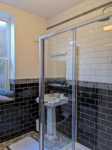 a bathroom with a sink and a glass shower at Dolce Central Lord St. Flat 2 in Southport