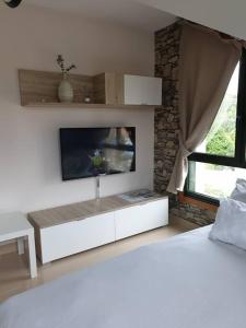 - un salon avec une télévision et un lit dans l'établissement RESIDENCIAL A MAMOA, à Carreira