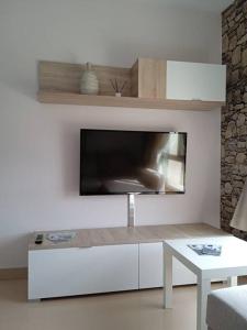 - un salon blanc avec une télévision et une table dans l'établissement RESIDENCIAL A MAMOA, à Carreira