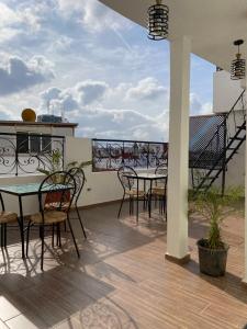 eine Terrasse mit Tischen und Stühlen auf dem Balkon in der Unterkunft Riad Jbara 2 in Rabat