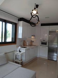 a kitchen with white cabinets and a chandelier at RESIDENCIAL A MAMOA in Carreira +25 photos