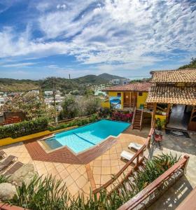 a swimming pool in front of a house at Pousada dos Atobás in Arraial do Cabo