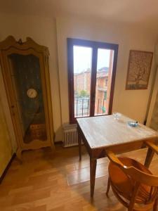 a dining room with a table and a large window at SpazioViola appartamento intimo boho style uno spazio magico per l'energia che si respira in un palazzo della vecchia Bologna Qui nulla è perfetto ma tutto racconta No Wi-Fi No aria condizionata in Bologna