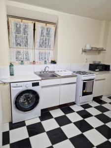 a kitchen with a washing machine and a sink at Waterloo - Zone 1 - Spacious one bedroom flat in London