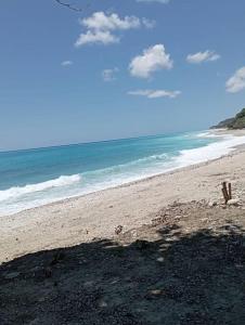 una playa de arena con el océano en el fondo en Agradable Apartamento, en Paraíso