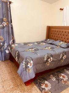 Una cama con un edredón azul con flores. en Agradable Apartamento, en Paraíso