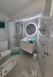 y baño blanco con lavabo y ducha. en Las Americas Best-Suite 10 -Studio Luxury con vista a 5 mins dalla spiaggia con 2 piscine en Playa Fañabe