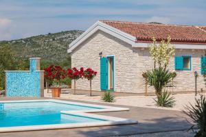a house with a swimming pool in front of a house at Villa Tovarovica in Primošten