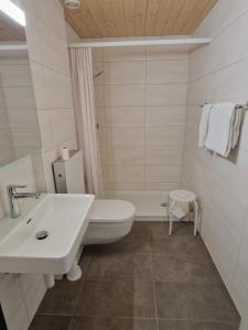 ein Badezimmer mit einem weißen WC und einem Waschbecken in der Unterkunft Auberge du Peu-Péquignot in Le Noirmont