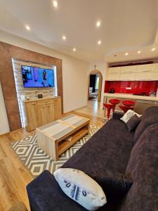 a living room with a couch and a tv at Sunny Apartment Centrum Zakopane in Zakopane