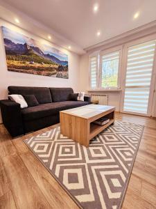 a living room with a couch and a coffee table at Sunny Apartment Centrum Zakopane in Zakopane