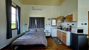 una piccola camera con letto e cucina di บ้านสวนลุงแจน ฟิชชิ่งพาร์ค แอนด์ รีสอร์ท 