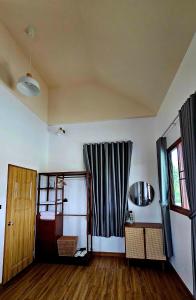 un soggiorno con pavimenti in legno e finestra di บ้านสวนลุงแจน ฟิชชิ่งพาร์ค แอนด์ รีสอร์ท 