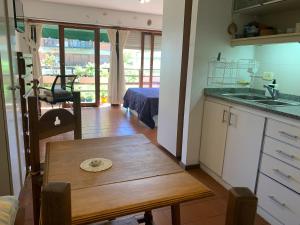 cocina con mesa de madera en una habitación en Lindo y cómodo departamento en Pinamar - Otilia Residencias en Pinamar