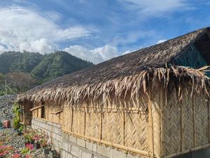 a wooden building with a thatched roof and flowers at Dream house 