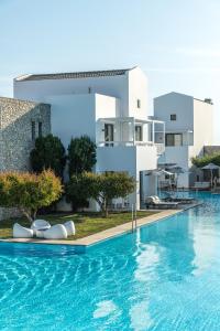 a villa with a swimming pool in front of a building at Diamond Deluxe Hotel - Adults Only in Kos Town