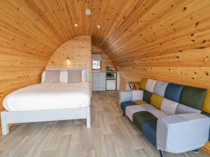 - une chambre dans une cabane en rondins avec un lit et un canapé dans l'établissement The Wheelhouse Pod No 6, à Letterkenny