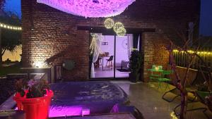 Pokój z ceglaną ścianą i patio z fioletowymi światłami w obiekcie GARY Suite - Studio Cosy, Spa et jardin privatif à 4 min de Cambrai w mieście Awoingt