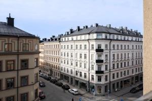 斯德哥爾摩的住宿－Stockholm Loft Haven 3 Beds in a 1- Bedroom Gem - 917，一条白色的大建筑,汽车停在街上