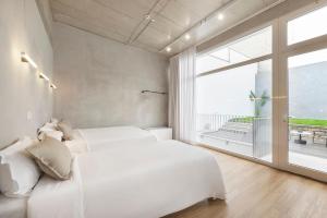 una camera con due letti bianchi e una grande finestra di Lisbon Oriente Apartments by Olala Homes a Lisbona