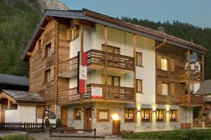a large wooden building with a balcony at Apart-hotel Channa in Saas-Almagell