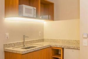 a kitchen with a sink and a microwave at Salinas Exclusive Resort in Salinópolis