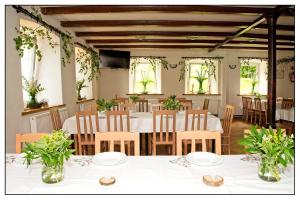 a dining room with tables and chairs and windows at Anna in Miłków