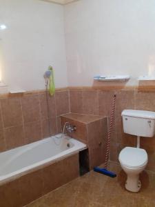 La salle de bains est pourvue de toilettes et d'une baignoire avec une serpillière. dans l'établissement Sunshine Villa House, à Brufut