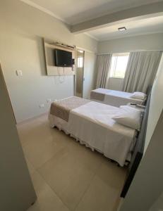 a hospital room with two beds and a tv at Hotel Boituva Inn - Your Hotel in Boituva