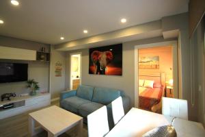una sala de estar con sofá y una pintura de elefante en la pared en Apartamento CasaTuris en 1ª Línea Muchavista Edificio Voramar C106, en El Campello