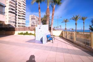 una persona que toma una foto de un banco y palmeras en Apartamento CasaTuris en 1ª Línea Muchavista Edificio Voramar C106, en El Campello