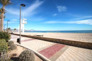 una playa de arena con un poste de luz y el océano en Apartamento CasaTuris en 1ª Línea Muchavista Edificio Voramar C106, en El Campello 10 fotos más