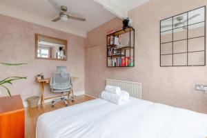 a bedroom with a bed and a desk and a chair at Stylish 2BD Home wPrivate Gym & Garden Newlands! in London