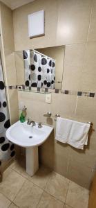 y baño con lavabo y espejo. en Casita de Tucumán Apart - Cochera Cercana en San Miguel de Tucumán