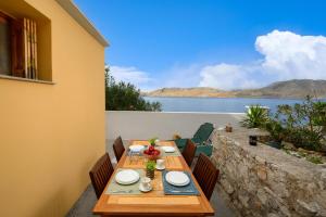 a table on a patio with a view of the water at Over The Sea Apartments in Symi