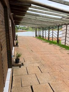 eine überdachte Terrasse mit Flussblick in der Unterkunft Cabanas MFK in Machadinho