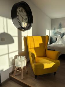a living room with a yellow chair and a clock at Urban Studio in Buttelstedt
