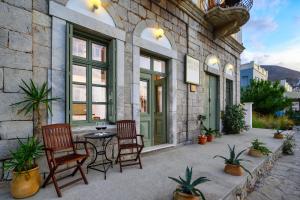 a patio with chairs and a table in front of a building at Over The Sea Apartments in Symi