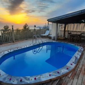 費特希耶的住宿－Esila bungalow sea and nature wiev，木制甲板上的大型蓝色游泳池